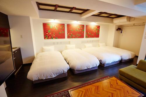 Zimmer mit 3 Betten und einem Sofa in der Unterkunft Hotel Sanriiott Kitahama - Vacation STAY 33531v in Osaka