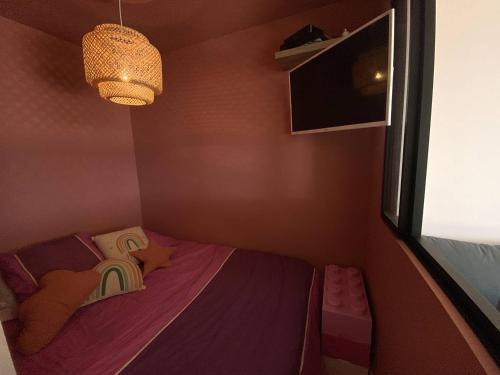 une petite chambre avec un lit et une fenêtre dans l'établissement Appartement avec terrasse en front de mer LES ROMARINS, à Narbonne-Plage