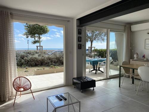 un salon avec vue sur l'océan dans l'établissement Appartement avec terrasse en front de mer LES ROMARINS, à Narbonne-Plage