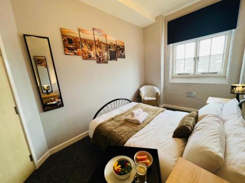 a bedroom with a bed and a table with a bowl of food on it at City Mill - Next to Town Centre Shopping and Restaurants - Free Parking in Burton upon Trent
