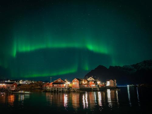 ein Bild der Aurora Borealis über einer Stadt in der Unterkunft Henningsvær Rorbuer in Henningsvær