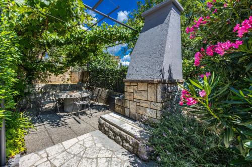 Un patio con una mesa y algunas flores rosas. en Apartments ALEXIS, en Crikvenica