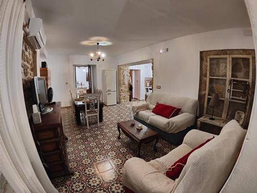 sala de estar con 2 sofás y TV en Apartamentos Casa Nino, en Montefrío
