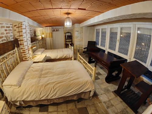 a bedroom with two beds and a desk and a piano at Apartamentos Casa Nino in Montefrío