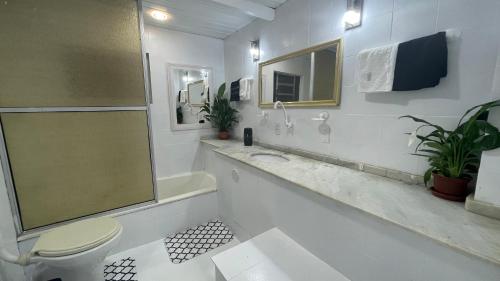 Baño blanco con aseo y lavamanos en APTO casa BRANCA na NATUREZA en Florianópolis