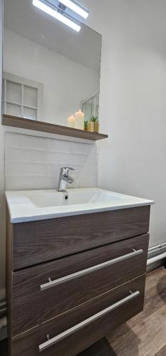 een badkamer met een wastafel en een spiegel bij L'atelier- Duplex Vue magnifique sur le port- in Saint-Valéry-en-Caux