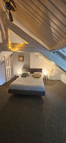 een slaapkamer met een groot bed op zolder bij L'atelier- Duplex Vue magnifique sur le port- in Saint-Valéry-en-Caux