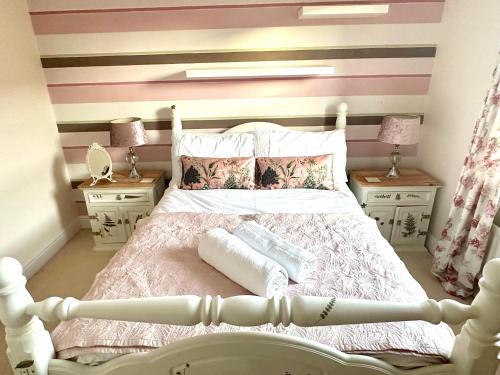 a bedroom with a bed with pink and purple stripes at 5 Bedroom Luxury House with Parking for 2 Cars in Desborough