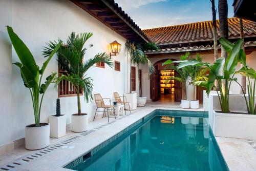 a villa with a swimming pool and a house at Palmas de Alba Hotel Boutique in Cartagena de Indias