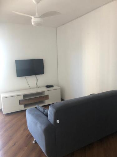 un soggiorno con divano e TV a schermo piatto di Apartamento Giovanni Gronchi a San Paolo
