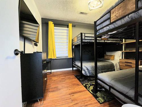 1 Schlafzimmer mit 2 Etagenbetten und einem Fenster in der Unterkunft HI-TEK MANOR 2 - Prime Location - 2-75 inch 4K TVs in Charleston