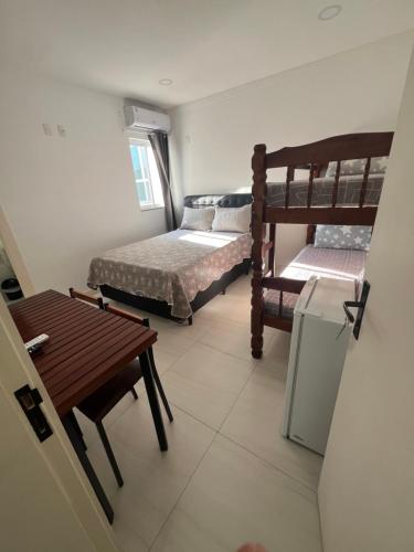 Cette petite chambre comprend 2 lits superposés et une table. dans l'établissement ECOSURF, à Cabo Frio