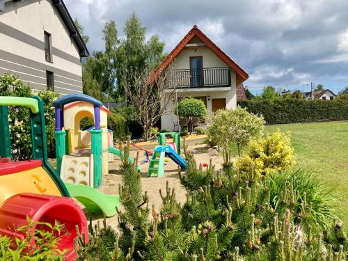 einen Garten mit Spielplatz vor einem Haus in der Unterkunft Fajne Domki in Władysławowo