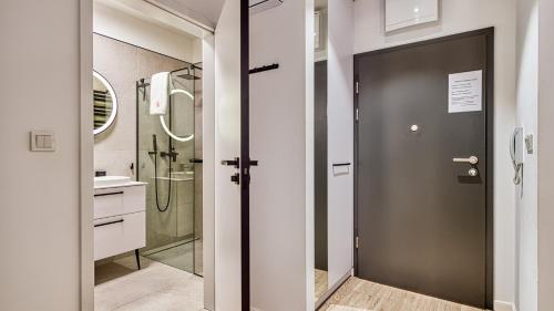 uma casa de banho com um chuveiro e uma porta de vidro em Rezydencja Niechorze 224 - 5D Apartamenty em Niechorze