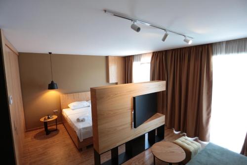 um quarto de hotel com uma cama e uma televisão de ecrã plano em Alvin Comfort Hotel em Durrës