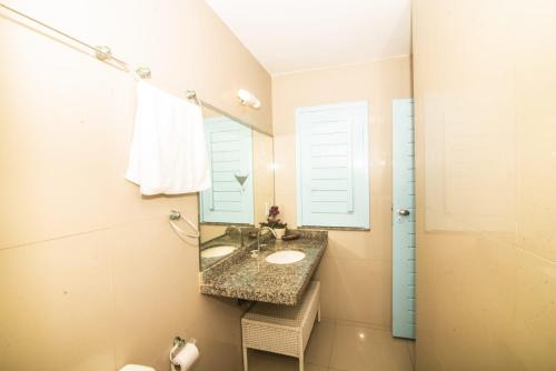 ein Bad mit einem Waschbecken und einem Spiegel in der Unterkunft Bellevie Experience in Cascavel