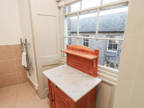 a bathroom with a wooden counter and a window at Upper Oakwood in Alnwick