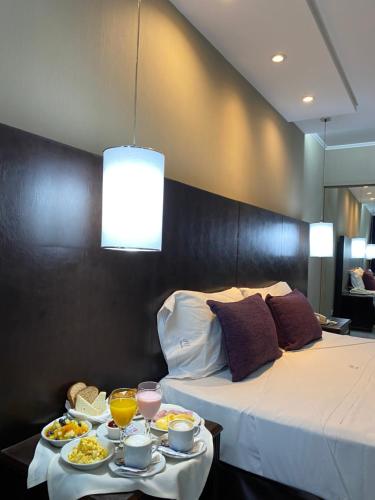 a hotel room with two beds and a tray of food at Howard Johnson Plaza by Wyndham Buenos Aires Florida Street in Buenos Aires