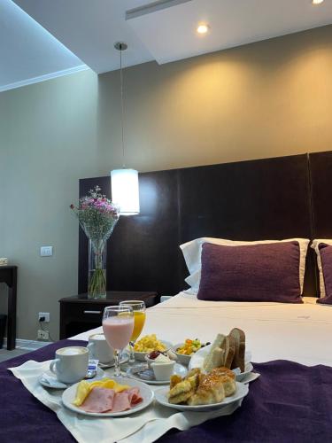 a breakfast tray with food and drinks on a bed at Howard Johnson Plaza by Wyndham Buenos Aires Florida Street in Buenos Aires
