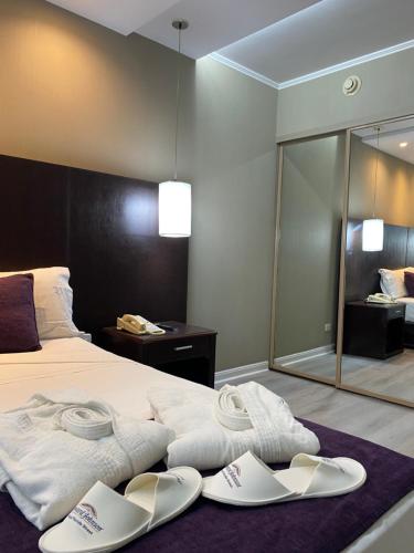 a bedroom with a bed with white shoes on it at Howard Johnson Plaza by Wyndham Buenos Aires Florida Street in Buenos Aires