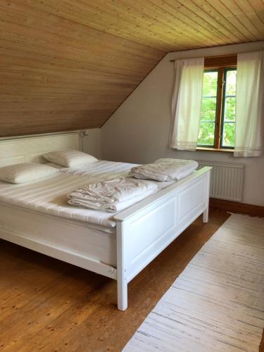 a white bed in a room with a window at Övra Berg in Ullared