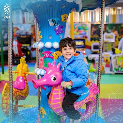 a young boy sitting on a toy horse on aousel at LUSINDA HOTEL MANAGEMENT BY ZAD in Suez