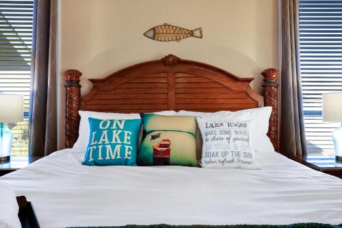 a bed with a wooden headboard and pillows on it at Lake House - A Birdy Vacation Rental in Canyon Lake