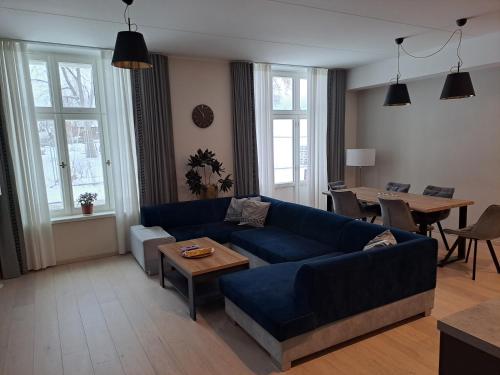 a living room with a blue couch and a table at Emajõe Keeltekool Apartment in Tartu
