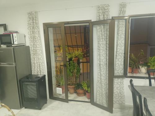 uma porta aberta com vasos de plantas num quarto em Piso junto al mar de 80m² em Villajoyosa