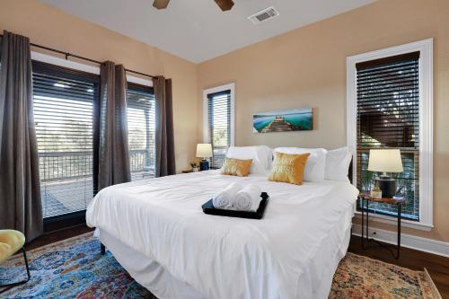 a bedroom with a large white bed with windows at Lake House - A Birdy Vacation Rental in Canyon Lake