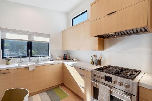 a kitchen with wooden cabinets and a stove top oven at Dazzling Modern Home Close to Downtown Palo Alto and Stanford in Menlo Park