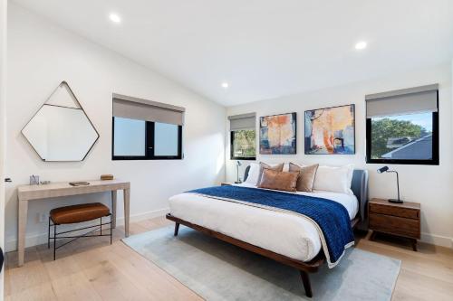 Schlafzimmer mit einem Bett, einem Schreibtisch und Fenstern in der Unterkunft Dazzling Modern Home Close to Downtown Palo Alto and Stanford in Menlo Park