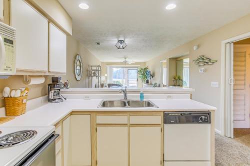 a kitchen with white cabinets and a sink at Pawleys Island Condo with Screened Porch and Golfing! in Pawleys Island