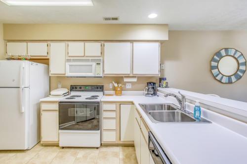 a kitchen with white appliances and a sink at Pawleys Island Condo with Screened Porch and Golfing! in Pawleys Island