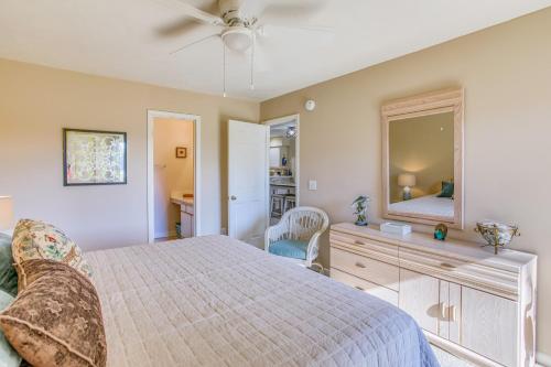 a bedroom with a bed and a dresser and a mirror at Pawleys Island Condo with Screened Porch and Golfing! in Pawleys Island