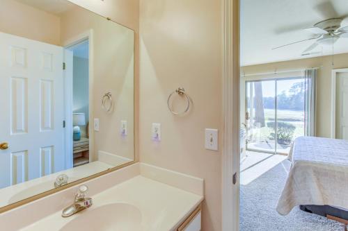 a bathroom with a sink and a mirror at Pawleys Island Condo with Screened Porch and Golfing! in Pawleys Island