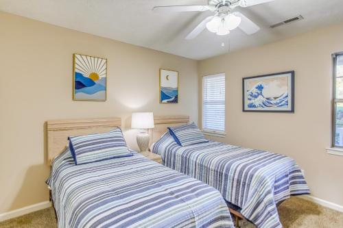 a bedroom with two beds and a ceiling fan at Pawleys Island Condo with Screened Porch and Golfing! in Pawleys Island