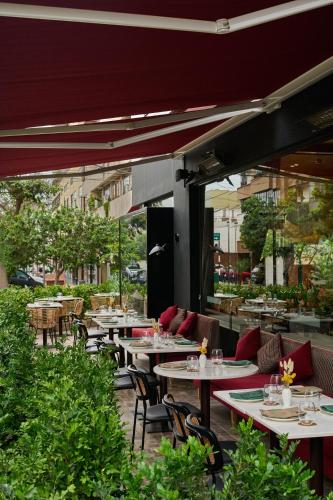 a restaurant with tables and chairs in a courtyard at Manto Hotel Lima - MGallery Collection in Lima