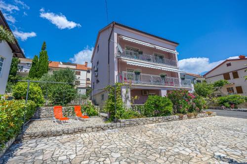 dos sillas naranjas sentadas frente a un edificio en Apartments ALEXIS, en Crikvenica