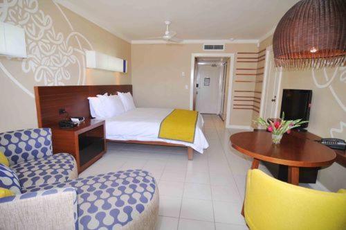 a hotel room with a bed and a table and chairs at Holiday Inn Resort Vanuatu by IHG in Port Vila