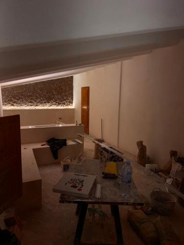ein unvollendetes Zimmer mit einem Tisch in der Mitte in der Unterkunft Casa del Santo - Deluxe Studio in Calpe