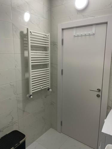 ein Bad mit einer Dusche und einer weißen Tür in der Unterkunft City Vibe in Obrenovac
