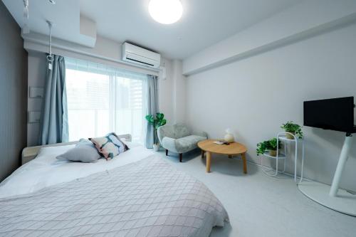 biała sypialnia z łóżkiem i telewizorem w obiekcie Seaside Tamachi - Vacation STAY 15581 w Tokio