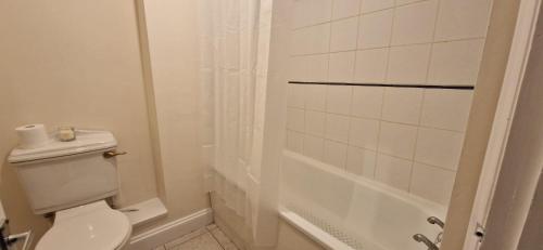 biała łazienka z toaletą i prysznicem w obiekcie Central Southampton Apartment Ocean Village w Southampton