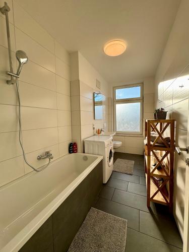 a bathroom with a tub and a toilet and a sink at Schicke Wohnung im grünen Hinterhof in Schwerin