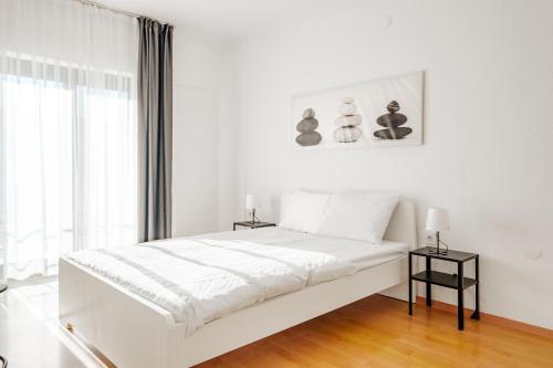 a white bedroom with a bed and a window at Flat with Terrace Close to Transit in Ankara in Ankara