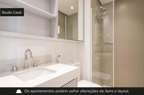 y baño blanco con lavabo y ducha. en Charlie Wide Pinheiros, en São Paulo