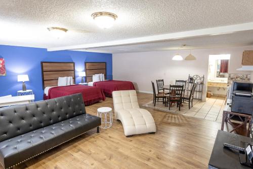 a hotel room with two beds and a living room at Motel Puyallup in Puyallup