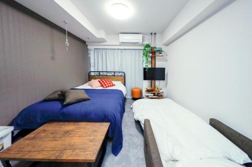a bedroom with two beds and a wooden table at Seaside Tamachi - Vacation STAY 15584 in Tokyo