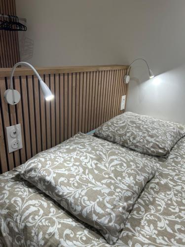 a bed with two pillows and a lamp on it at LESLIELOU T2 in La Ciotat